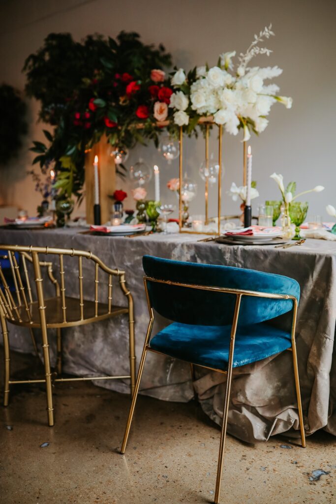 colorful maximalist reception table with gold and velvet chairs