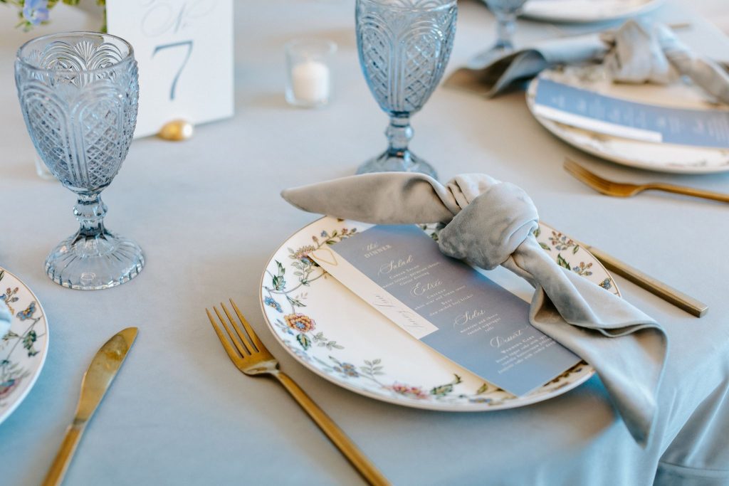 pastel blue wedding reception table with floral china