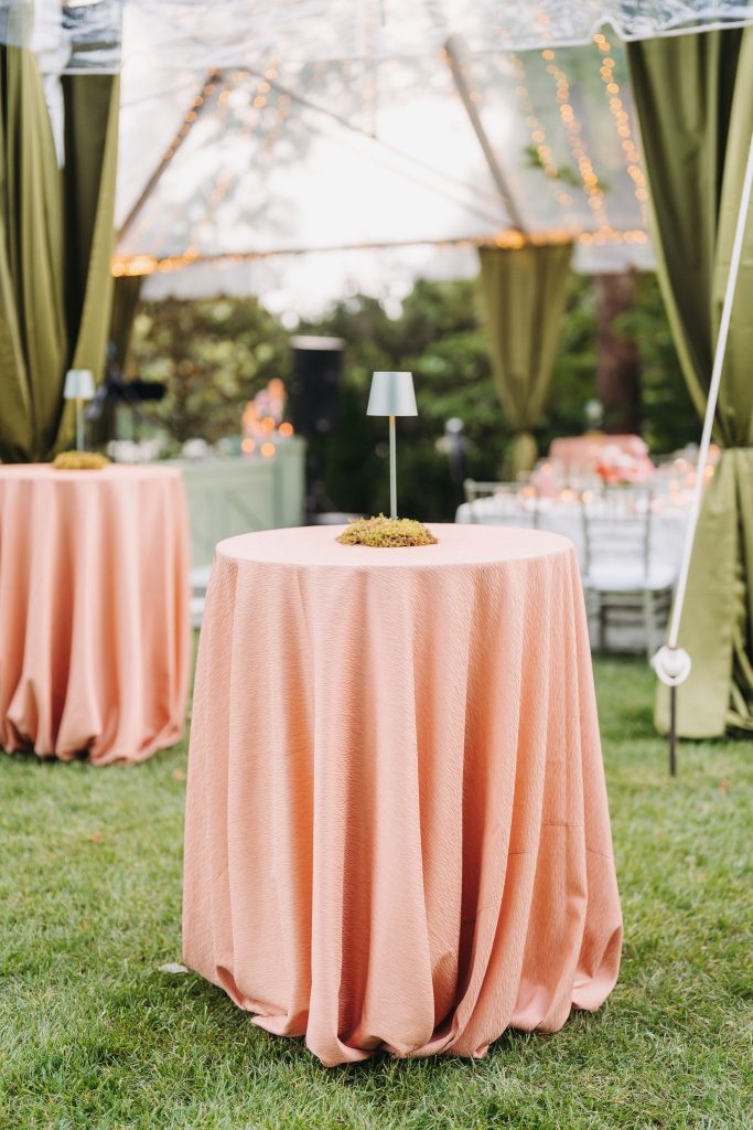 bistro table with pink tablecloth and gold table lamp